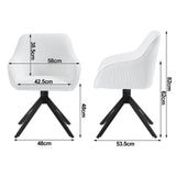 Twee draaibare BukkitBow corduroy eetkamerstoelen met armleuningen, zwart gekleed, op een eettafel met decoratieve accessoires.